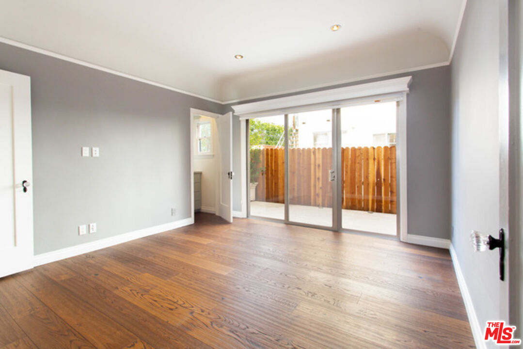 153 North Arnaz Drive Beverly Hills, CA 90211 - Photo 18 of 20 a view of an empty room with wooden floor and a window