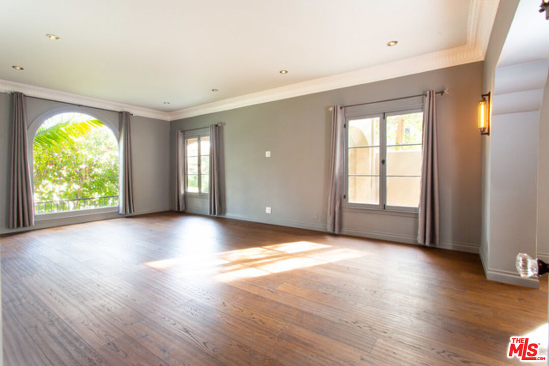 153 North Arnaz Drive Beverly Hills, CA 90211 - Photo 3 of 20 a view of an empty room with wooden floor and windows