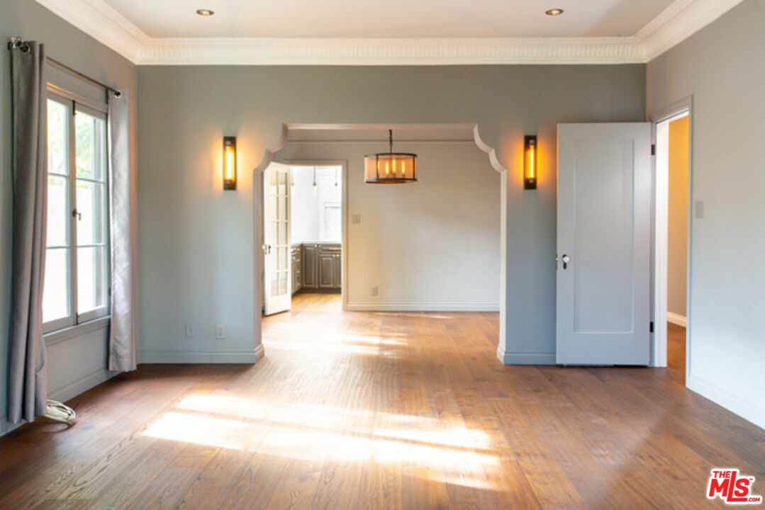 153 North Arnaz Drive Beverly Hills, CA 90211 - Photo 8 of 20 a view of an empty room with wooden floor and a window