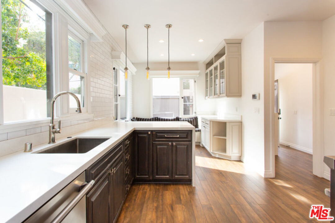 153 North Arnaz Drive Beverly Hills, CA 90211 - Photo 9 of 20 a large kitchen with kitchen island a large counter top space a sink stainless steel appliances and cabinets