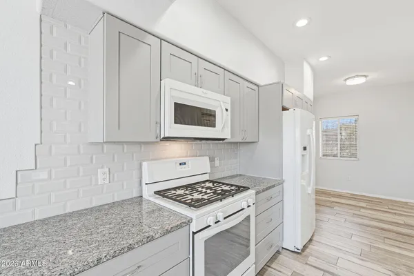 a kitchen with stainless steel appliances white cabinets and a stove top oven