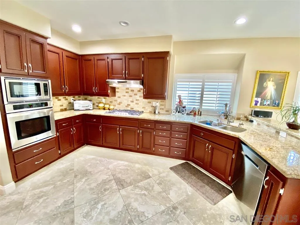 1988 Monarch Ridge Circle El Cajon, CA 92019 - Photo 4 of 27 a kitchen with stainless steel appliances granite countertop a stove sink and microwave