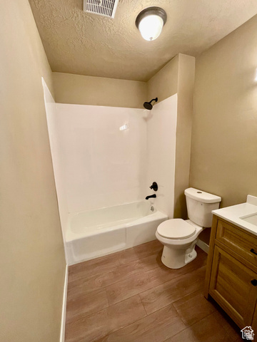 255 West Main Street Mount Pleasant, UT 84647 - Photo 22 of 35 Bathroom featuring a white tub/shower combination with black fixtures, a white toilet, and a wood-finish vanity with a light-colored countertop