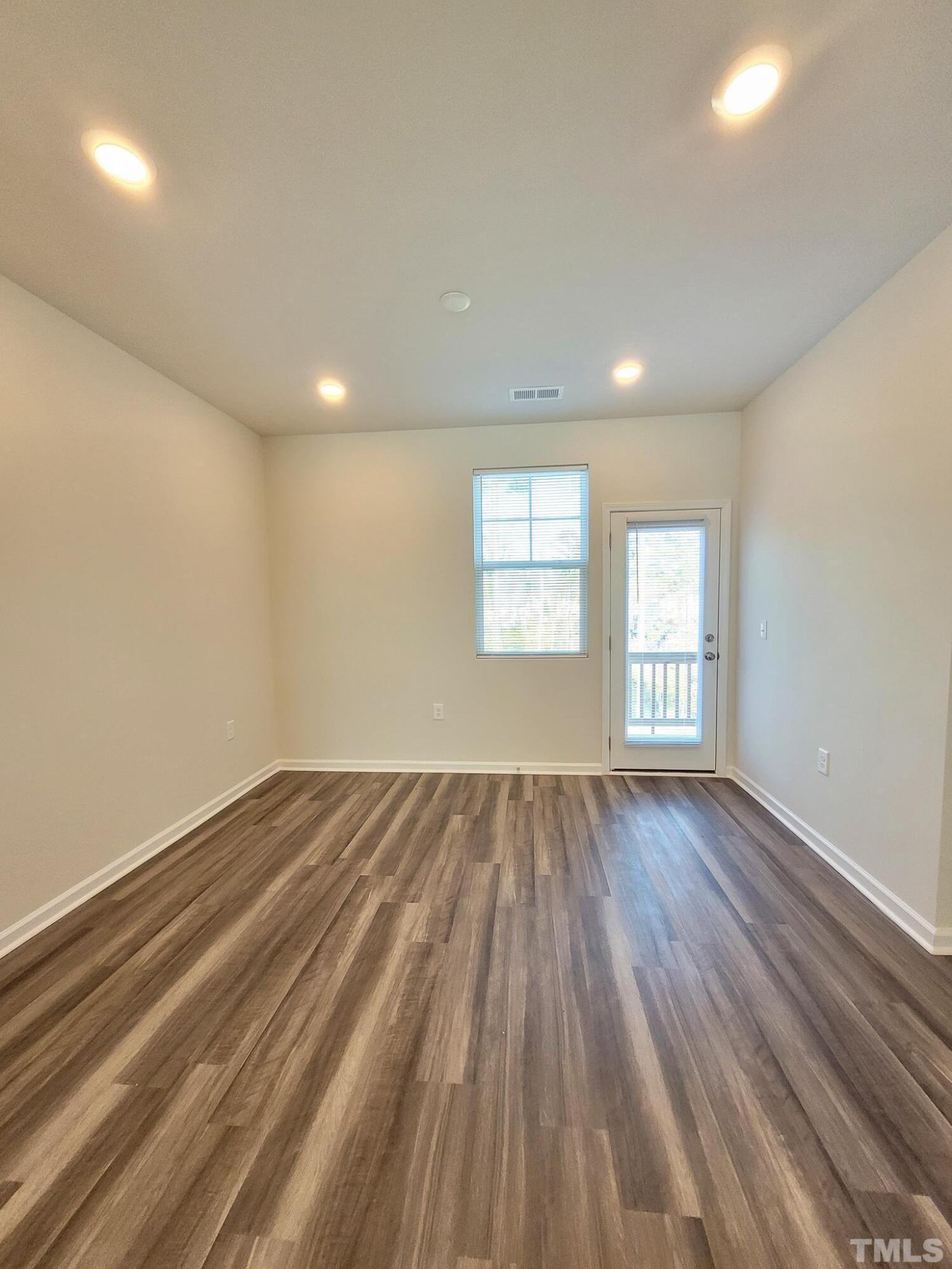 1038 Shoreside Drive Durham, NC 27713 - Photo 11 of 42 an empty room with wooden floor and windows