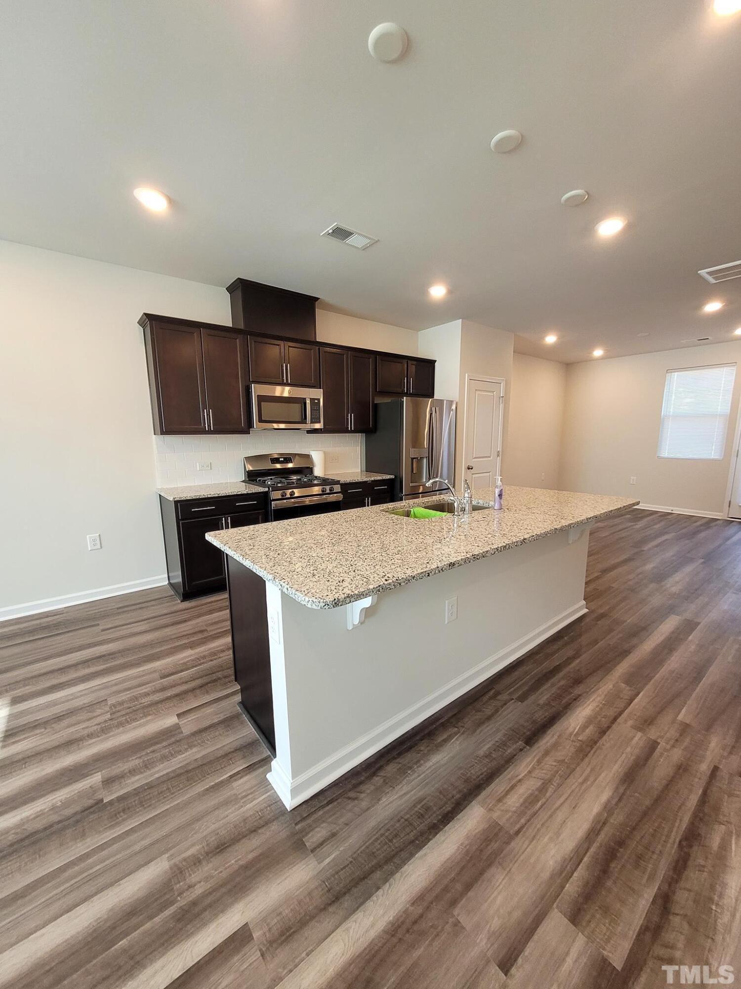 1038 Shoreside Drive Durham, NC 27713 - Photo 13 of 42 a kitchen with stainless steel appliances granite countertop a stove a sink and a refrigerator
