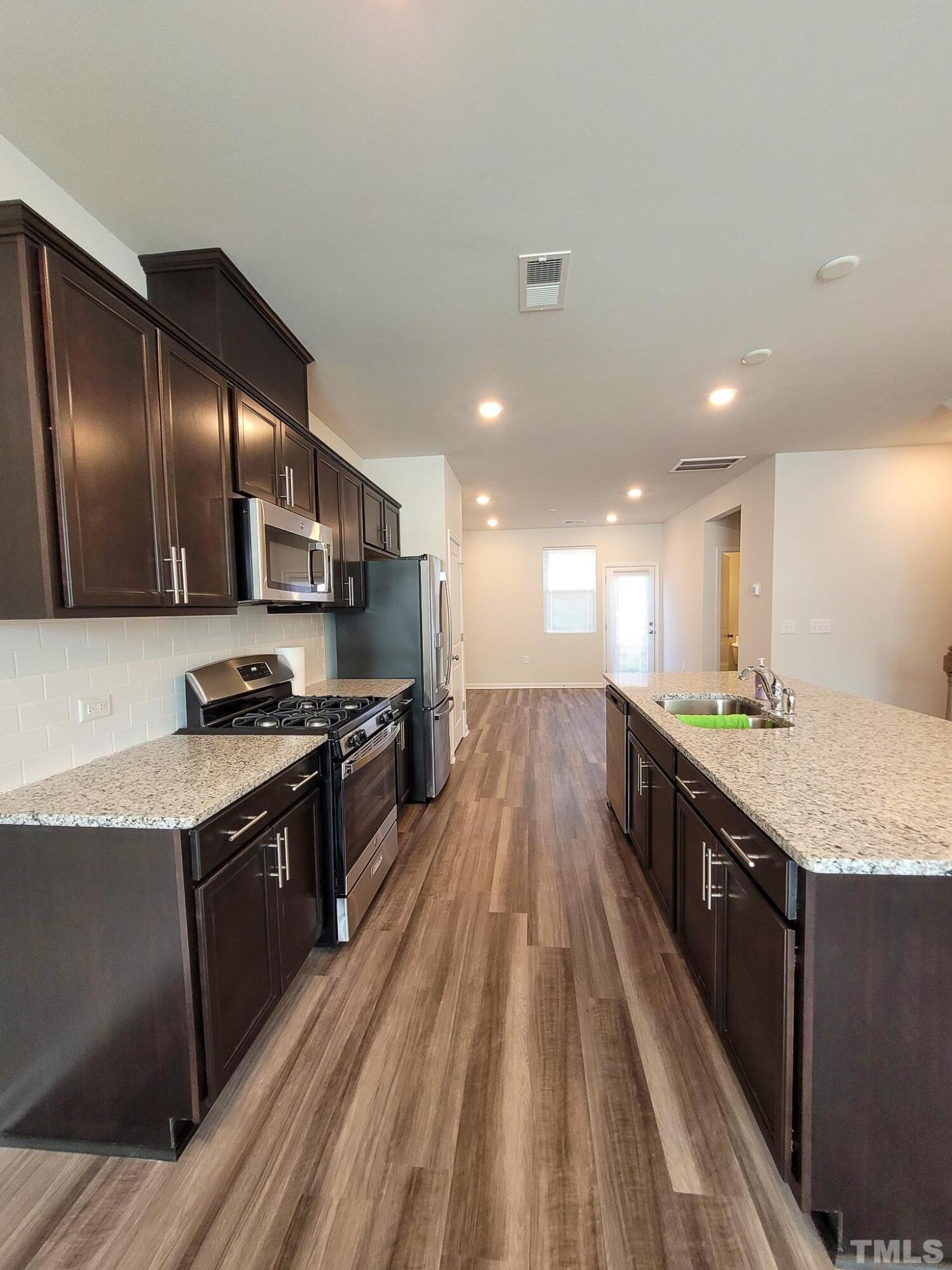 1038 Shoreside Drive Durham, NC 27713 - Photo 14 of 42 a large kitchen with stainless steel appliances granite countertop a lot of counter space
