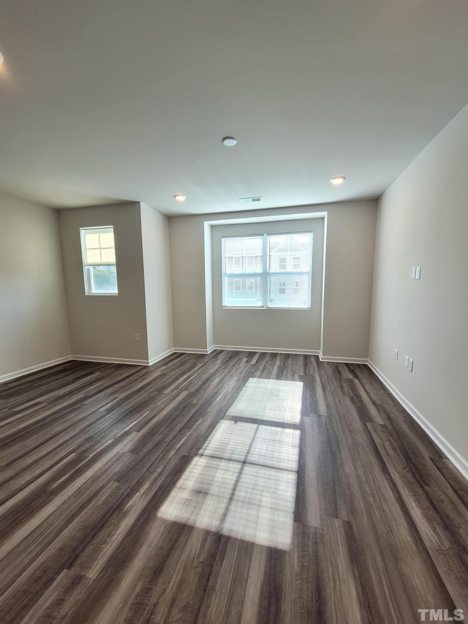1038 Shoreside Drive Durham, NC 27713 - Photo 18 of 42 an empty room with wooden floor and windows