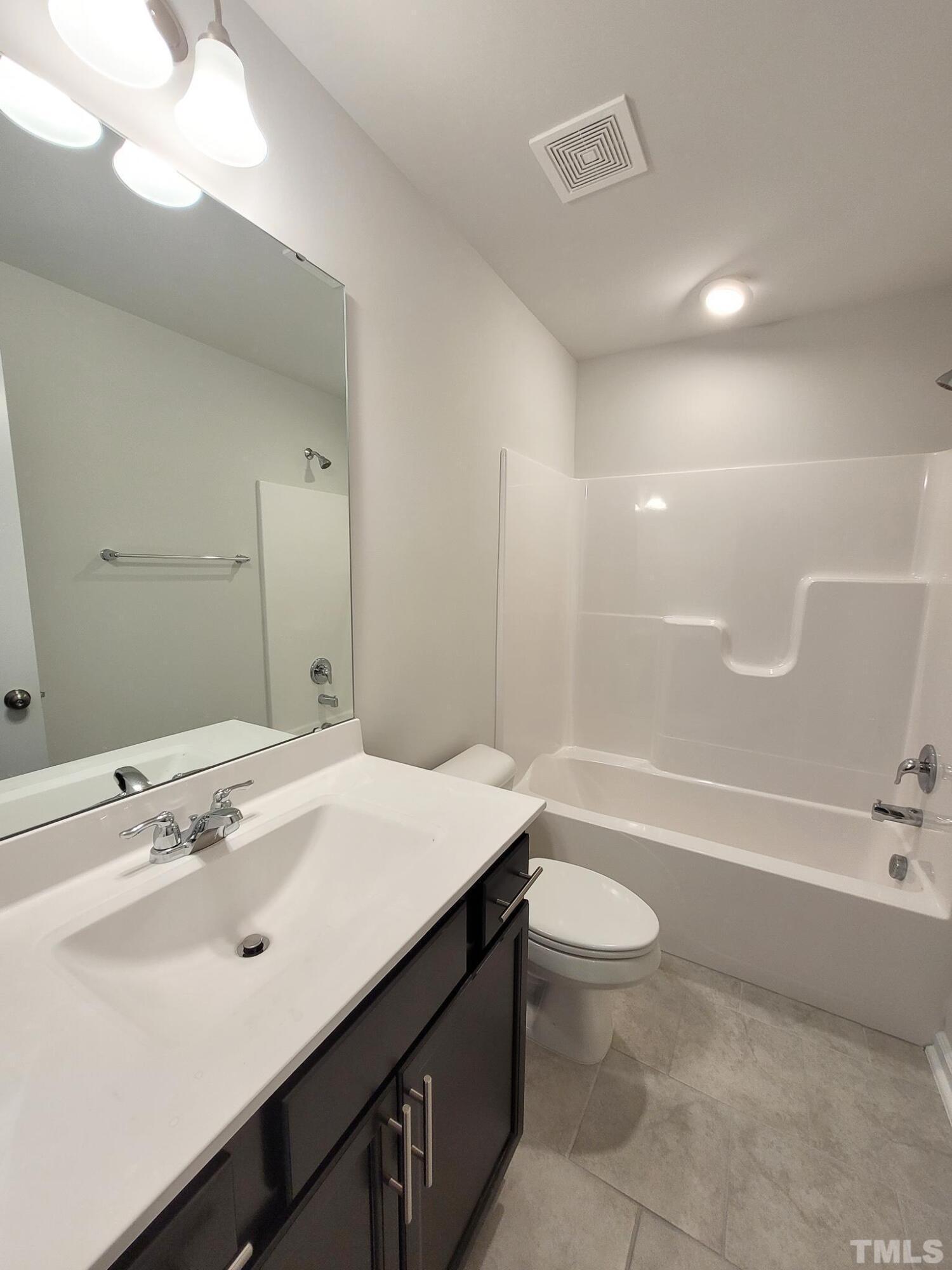1038 Shoreside Drive Durham, NC 27713 - Photo 8 of 42 a bathroom with a sink a toilet a mirror and bathtub
