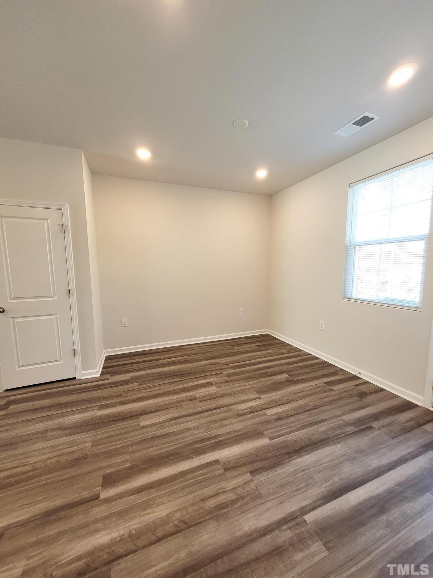 1038 Shoreside Drive Durham, NC 27713 - Photo 10 of 42 an empty room with wooden floor and windows