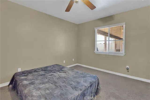 a spacious bedroom with a bed and a chandelier