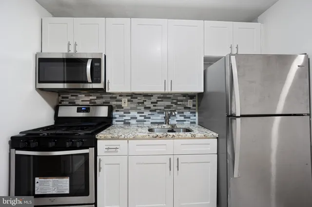 a kitchen with a refrigerator stove and cabinets