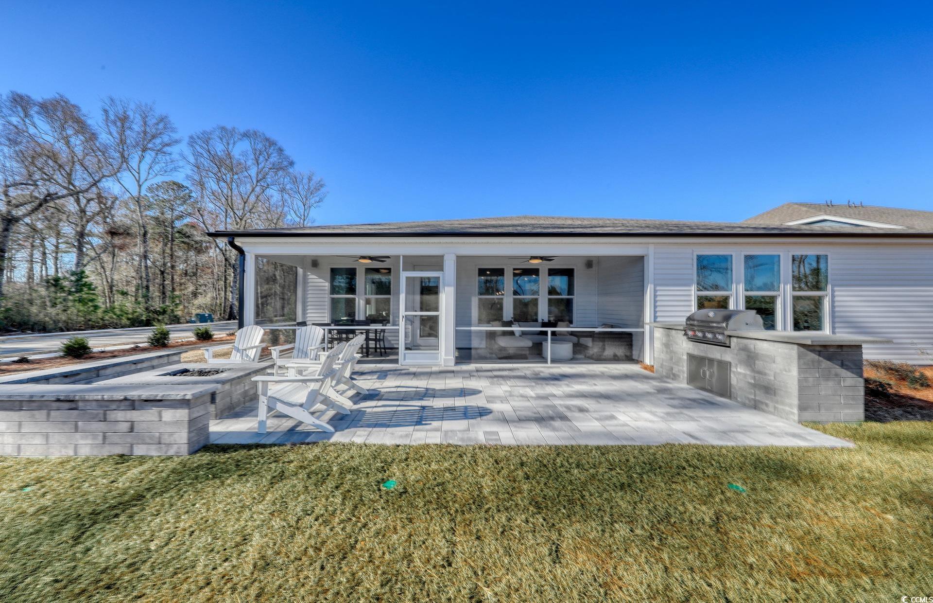 1514 Winding Crk Way Myrtle Beach, SC 29588 - Photo 14 of 20 Back of house featuring an outdoor kitchen, ceiling fan, a fire pit, and a yard