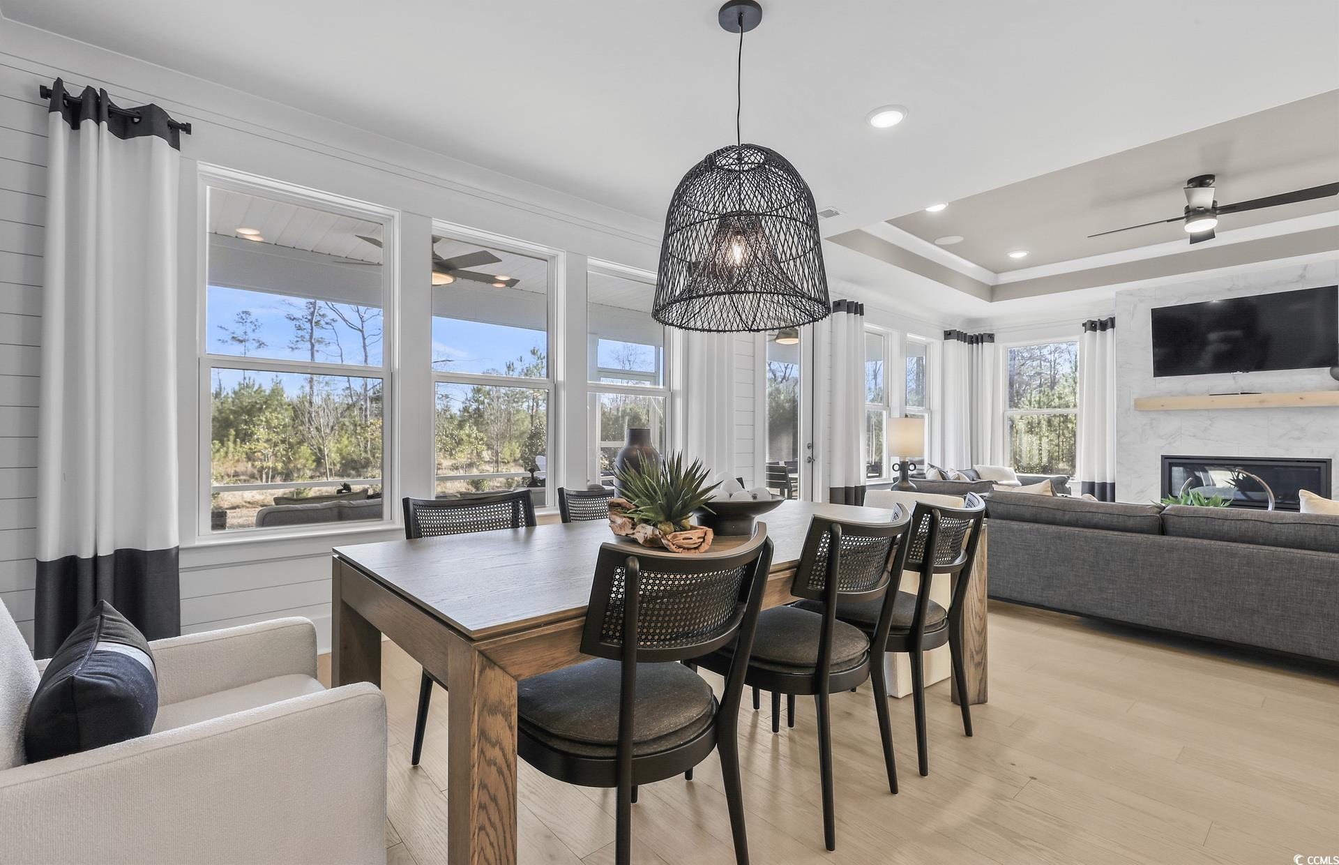 1514 Winding Crk Way Myrtle Beach, SC 29588 - Photo 8 of 20 Dining room featuring a ceiling fan, a fireplace, light wood finished floors, recessed lighting, and a chandelier