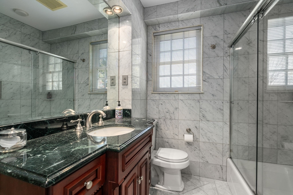 41 Nobscot Road Newton, MA 02459 - Photo 30 of 37 a bathroom with a granite countertop sink a toilet a mirror and shower