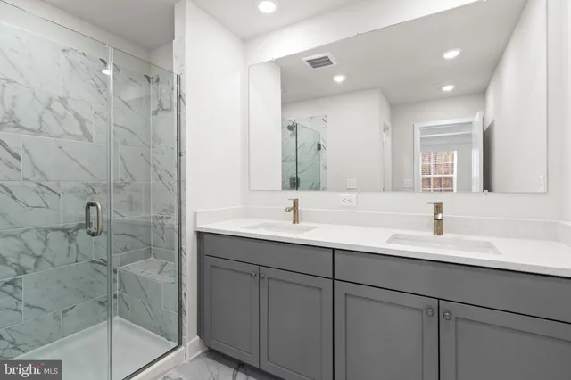 a bathroom with a double vanity sink mirror and shower