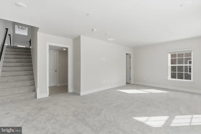 an empty room with windows and cabinet