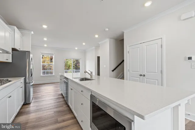 a large kitchen with stainless steel appliances a large counter top a stove and a refrigerator