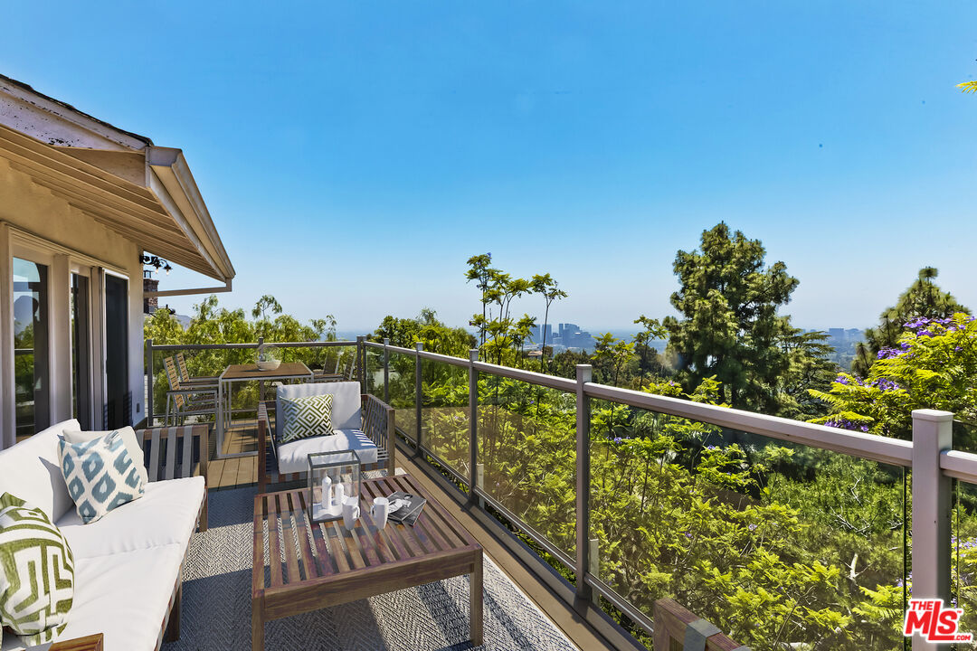 a balcony with wooden floor and outdoor seating