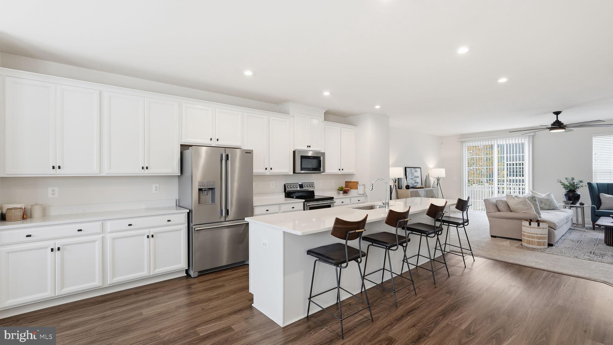 10644 Hinton Way Manassas, VA 20112 - Photo 11 of 44 a living room with stainless steel appliances kitchen island granite countertop a refrigerator a stove a sink dishwasher and white cabinets with wooden floor