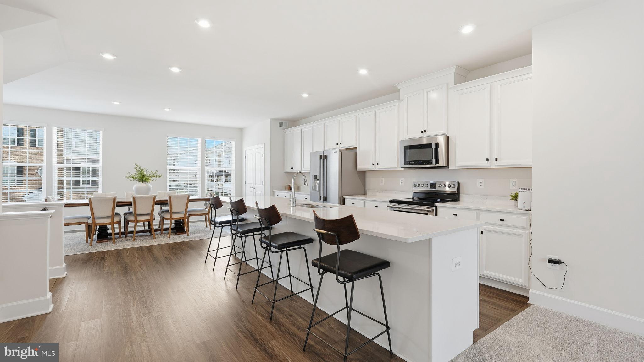 10644 Hinton Way Manassas, VA 20112 - Photo 12 of 44 a living room with stainless steel appliances a dining table wooden floor and a view of kitchen