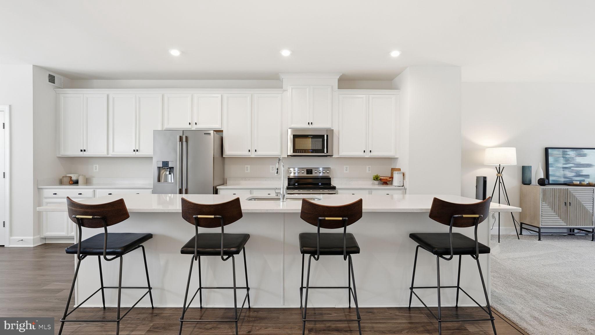 10644 Hinton Way Manassas, VA 20112 - Photo 9 of 44 a kitchen with stainless steel appliances kitchen island granite countertop a dining table chairs and a refrigerator