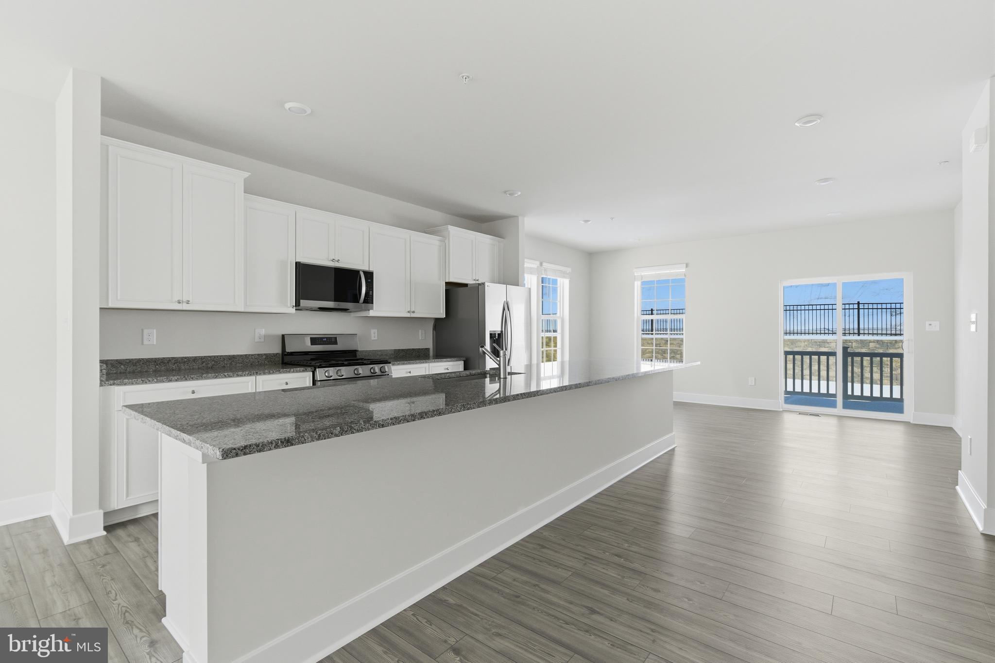 1723 Water Xing Road Pikesville, MD 21208 - Photo 13 of 37 a white kitchen with wooden floor and a sink