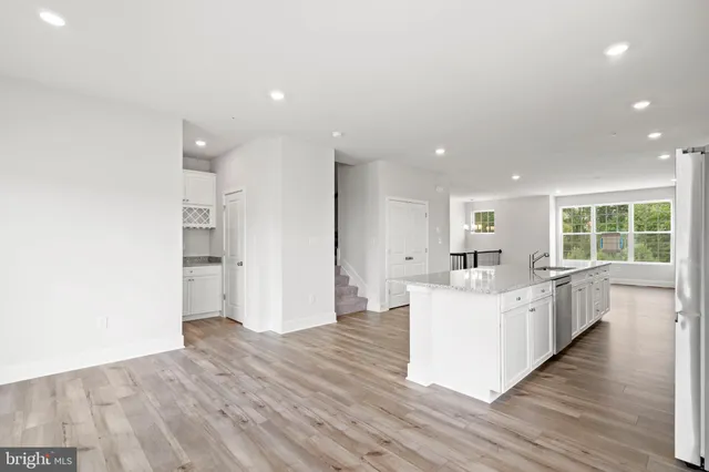 a large white kitchen with wooden floor and floors