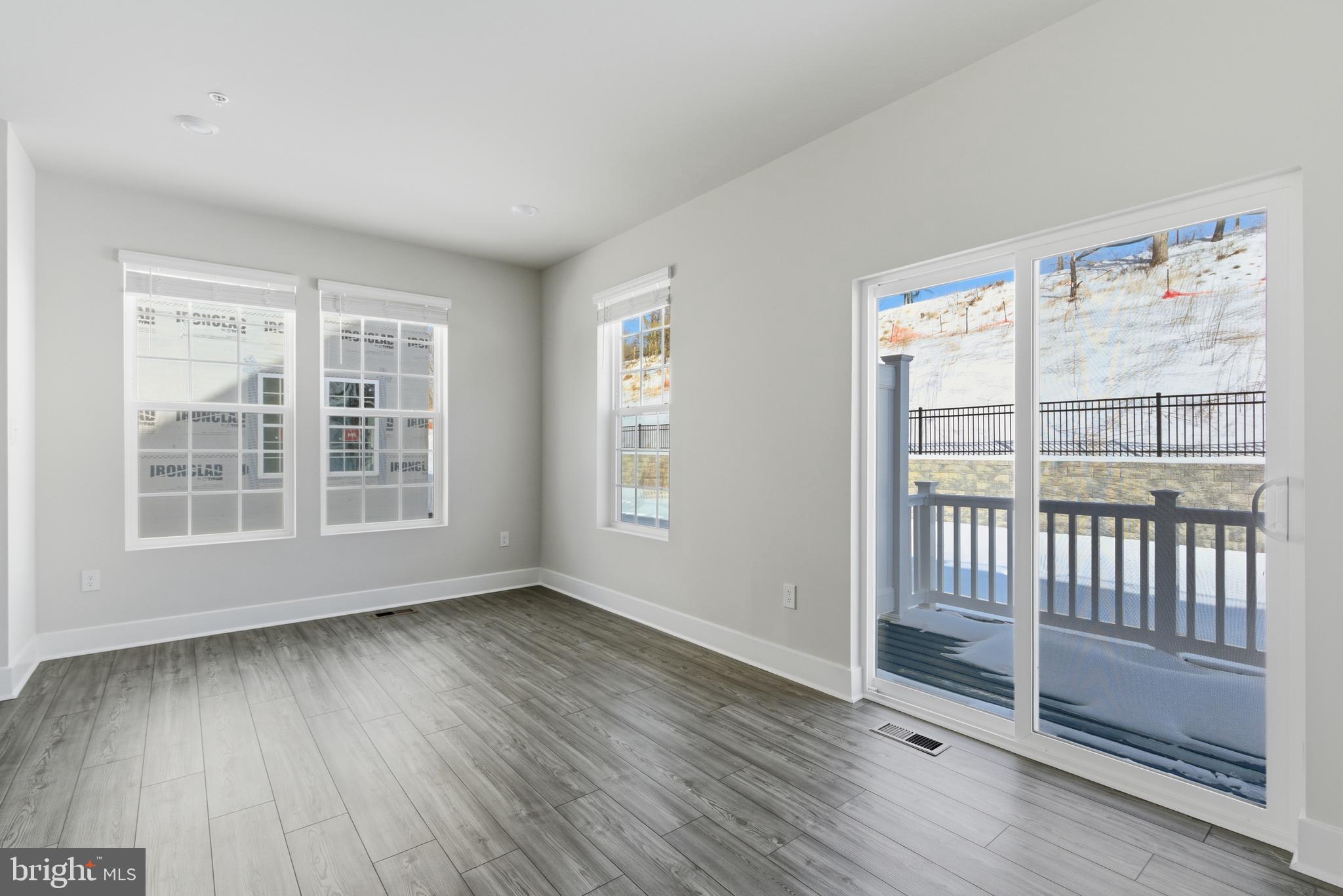 1723 Water Xing Road Pikesville, MD 21208 - Photo 16 of 37 a view of an empty room with wooden floor and a window