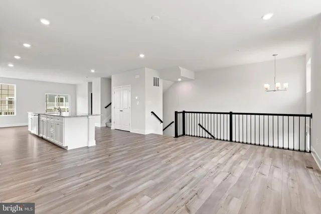 a view of a hallway with wooden floor and a sink