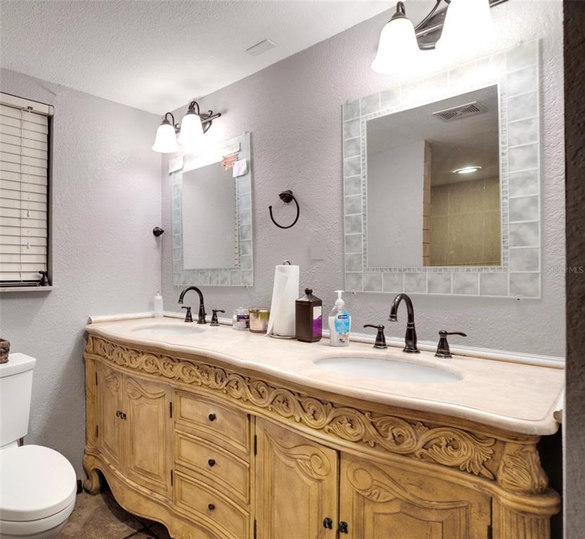 7905 Pierce Harwell Road Plant City, FL 33565 - Photo 34 of 68 a bathroom with a double vanity sink and a mirror
