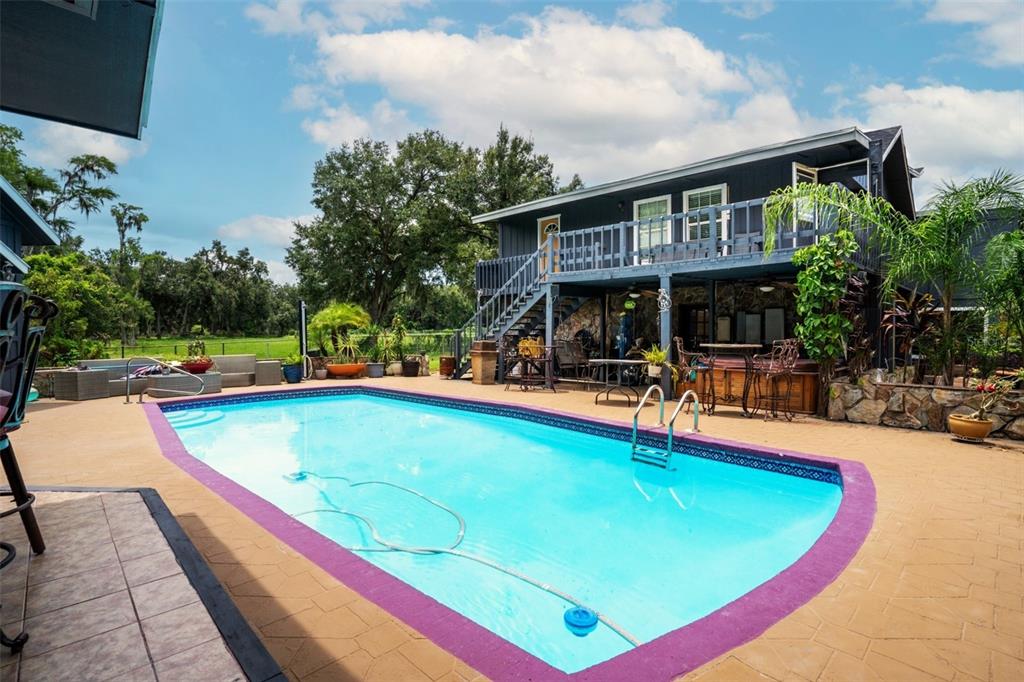 7905 Pierce Harwell Road Plant City, FL 33565 - Photo 43 of 68 a swimming pool view with a seating space and a garden view