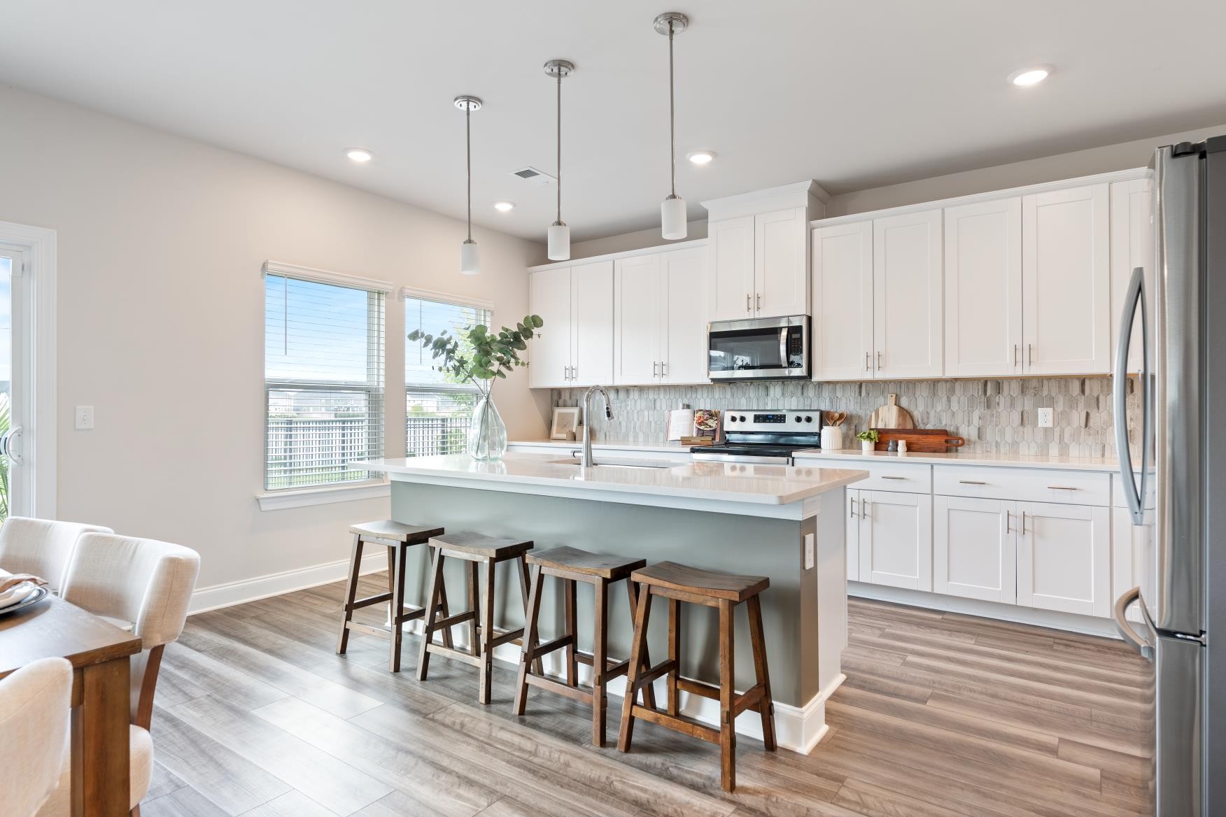 3706 Mathewson Way Murfreesboro, TN 37128 - Photo 13 of 59 a kitchen with stainless steel appliances granite countertop a stove a sink a microwave a refrigerator a stove a dining table and chairs with wooden floor
