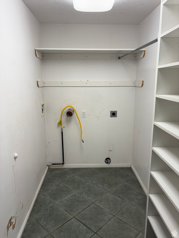 587 West 2400 South Perry, UT 84302 - Photo 16 of 46 Laundry area featuring tiled flooring, built-in shelving, a clothes rod, and utility hookups