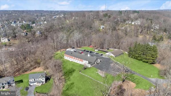 an aerial view of a house with swimming pool and large trees