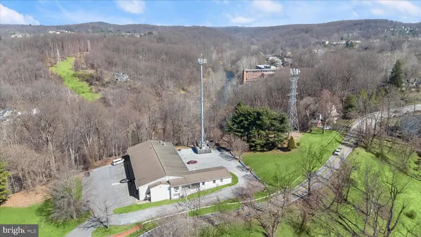 an aerial view of residential house with outdoor space and trees all around