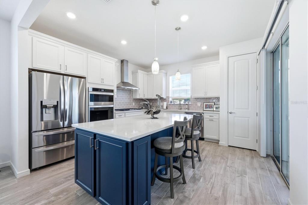 8706 Ocean Tides Cove Parrish, FL 34221 - Photo 11 of 63 a kitchen with kitchen island white cabinets and stainless steel appliances
