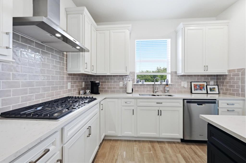 8706 Ocean Tides Cove Parrish, FL 34221 - Photo 15 of 63 a kitchen with white cabinets sink and appliances