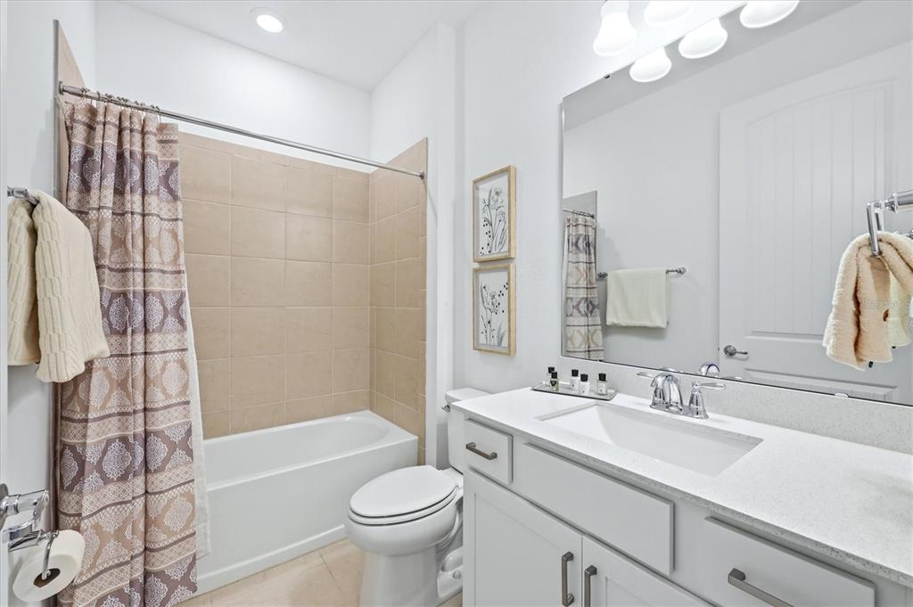 8706 Ocean Tides Cove Parrish, FL 34221 - Photo 26 of 63 a bathroom with a sink a toilet a mirror a bathtub and shower