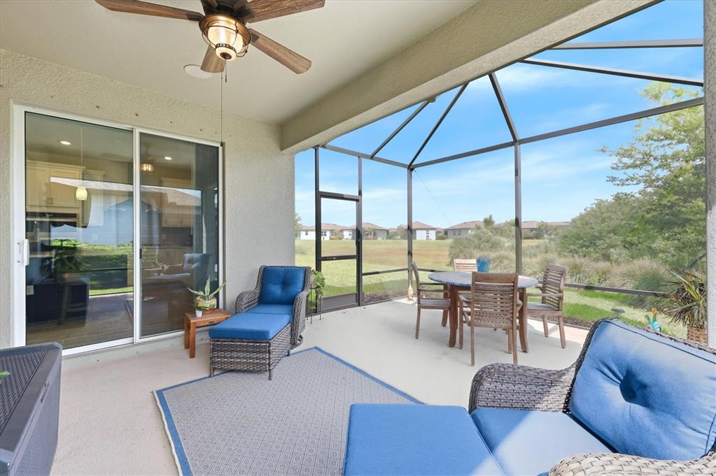 8706 Ocean Tides Cove Parrish, FL 34221 - Photo 29 of 63 a living room with furniture and a floor to ceiling window