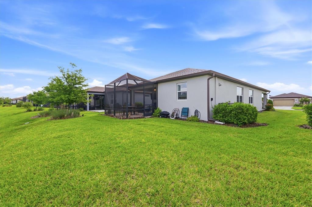 8706 Ocean Tides Cove Parrish, FL 34221 - Photo 32 of 63 a view of a yard in front of a house with plants and large tree
