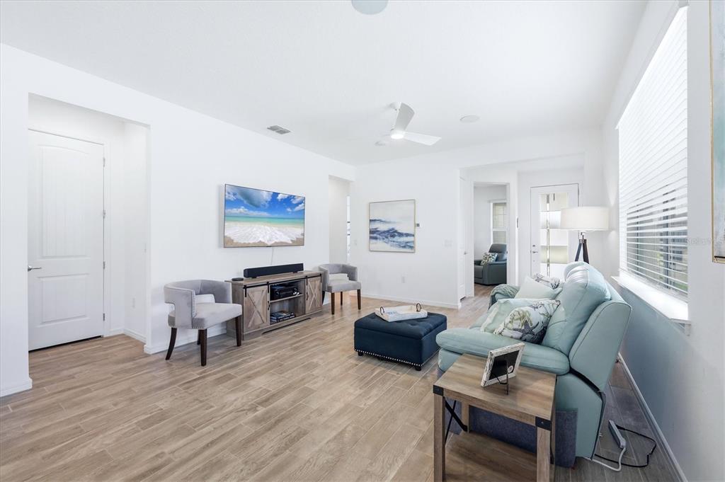 8706 Ocean Tides Cove Parrish, FL 34221 - Photo 8 of 63 a living room with furniture flat screen tv and wooden floor
