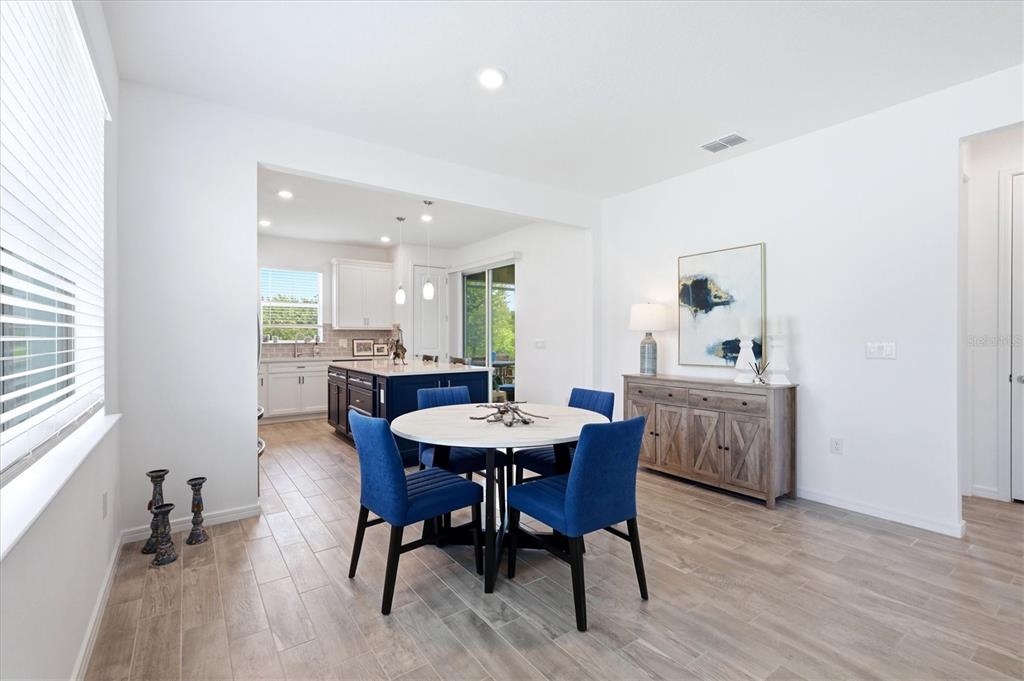 8706 Ocean Tides Cove Parrish, FL 34221 - Photo 10 of 63 a view of a dining room with furniture and wooden floor