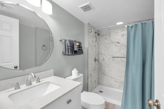 a bathroom with a sink a toilet and shower