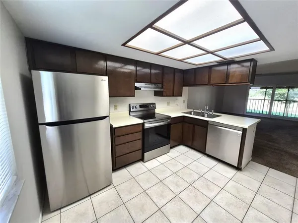a kitchen with stainless steel appliances granite countertop a refrigerator stove a sink and dishwasher