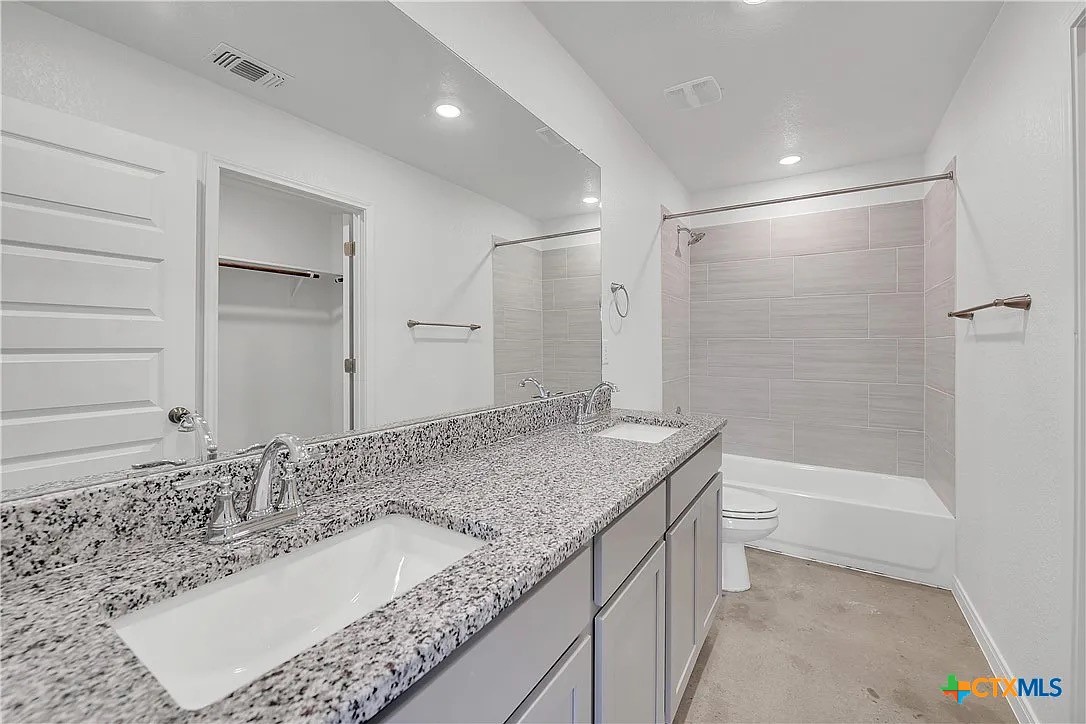 908 Smoke Tree Lane, Unit A Killeen, TX 76543 - Photo 8 of 13 a bathroom with a granite countertop sink a toilet and shower