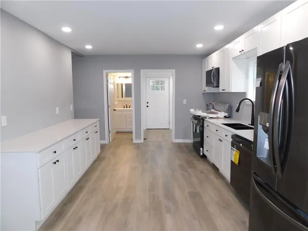 a kitchen with stainless steel appliances a refrigerator sink and cabinets