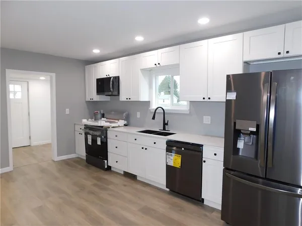 a kitchen with stainless steel appliances a refrigerator sink and microwave