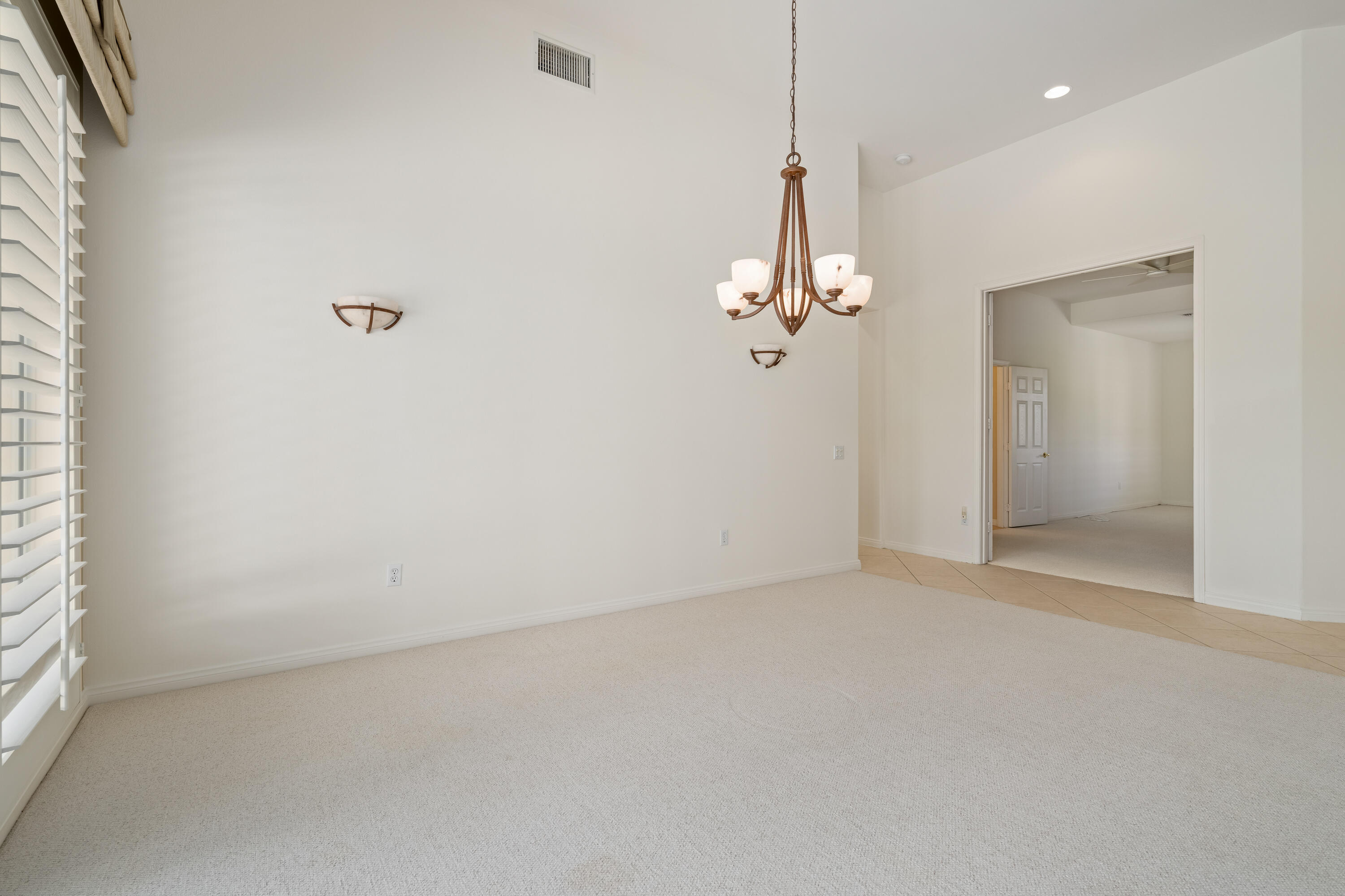 35260 Monarch Way Palm Desert, CA 92211 - Photo 16 of 44 an empty room with a chandelier fan and windows