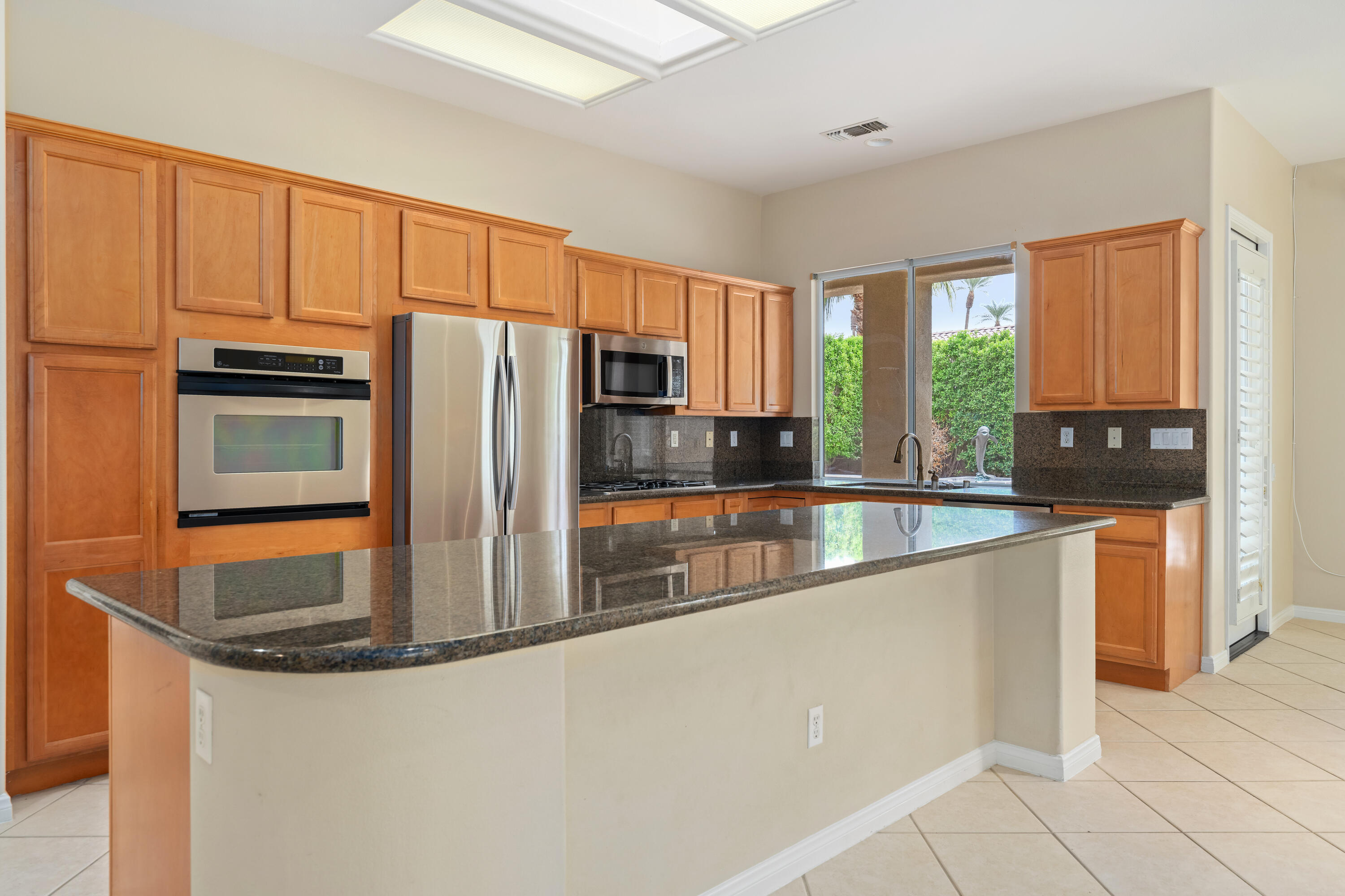 35260 Monarch Way Palm Desert, CA 92211 - Photo 18 of 44 a kitchen with stainless steel appliances granite countertop a refrigerator a stove and a sink with large window