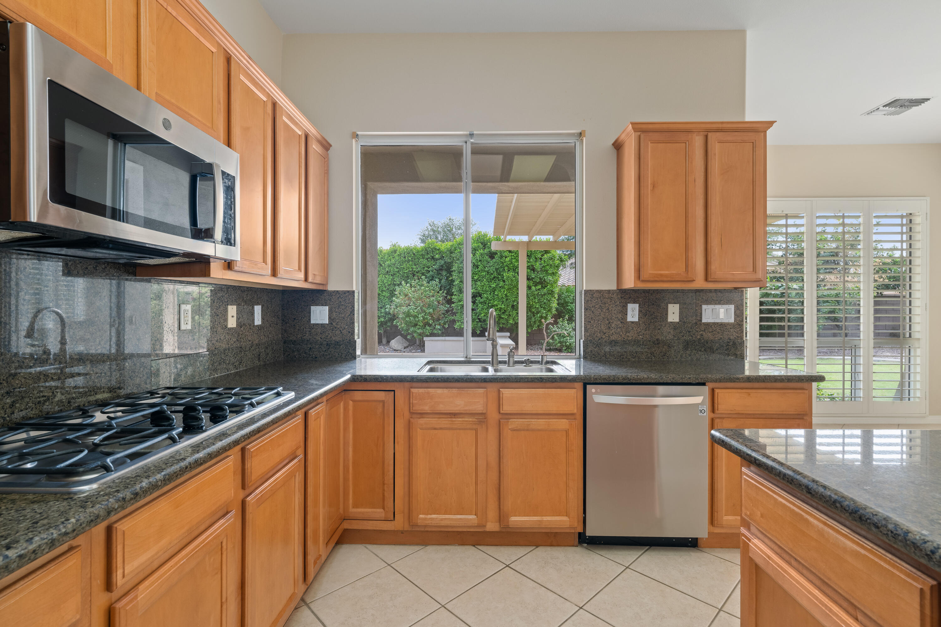 35260 Monarch Way Palm Desert, CA 92211 - Photo 21 of 44 a kitchen with stainless steel appliances granite countertop a stove a sink and a microwave